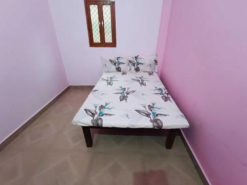 a small bed in a corner of a room at Hotel O Homes Maithli Raman Kunj Homestay in Ayodhya