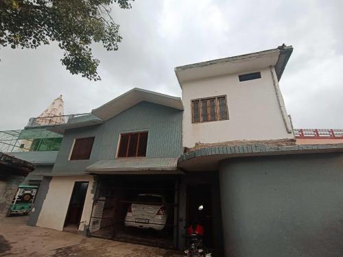 a house with a green and white building at Hotel O Homes Maithli Raman Kunj Homestay in Ayodhya
