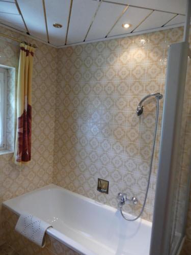 a bathroom with a bath tub and a shower at Haus Kröll in Mittersill