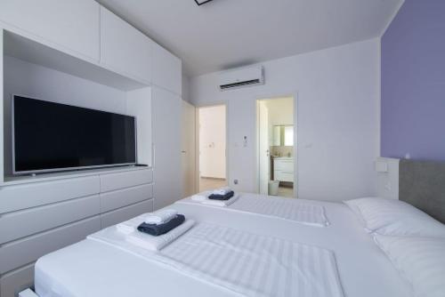 - une chambre blanche avec 2 lits et une télévision à écran plat dans l'établissement Villa Aron, à Svetvinčenat