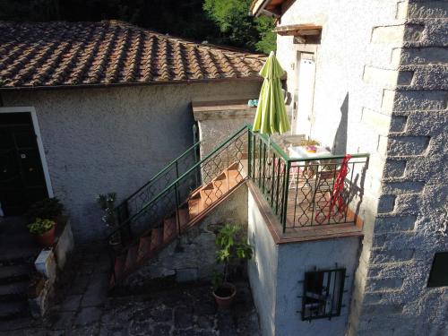 an external stairway with an umbrella and a patio at La Casa del Nonno - Tiny House in Reggello