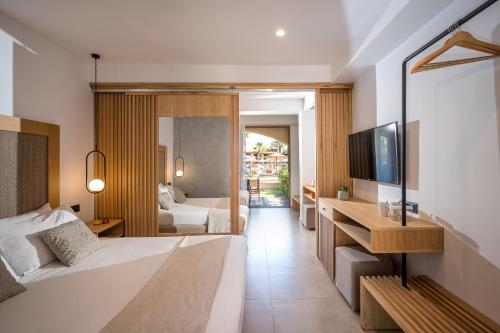a bedroom with a bed and a television in a room at Stella Palace Aqua Park Resort in Hersonissos