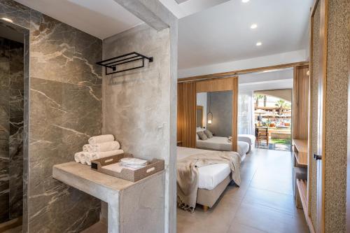 a hotel room with a bed and a bathroom at Stella Palace Aqua Park Resort in Hersonissos