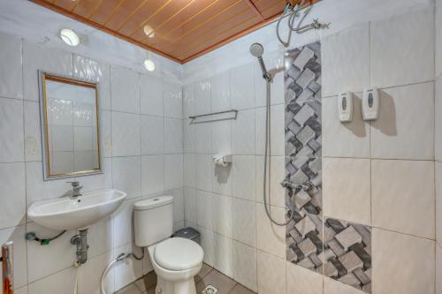 a bathroom with a toilet and a sink and a shower at Kira Cottages in Nusa Penida