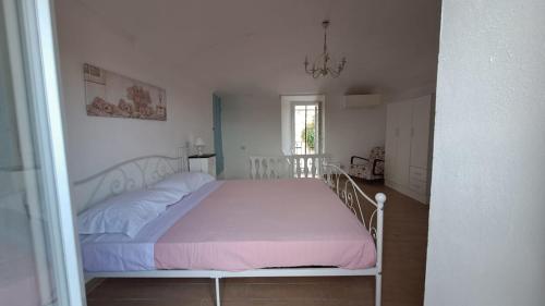 a bedroom with a white bed with a pink blanket at La Casetta di Treville in Ozzano Monferrato