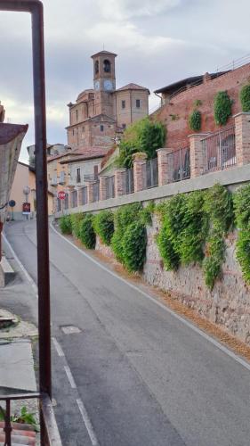 an empty street with a building with a clock tower at La Casetta di Treville in Ozzano Monferrato