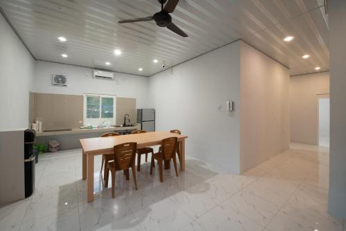 a kitchen with a table and chairs and a ceiling fan at Lombokhouse Mandalika in Kuta Lombok