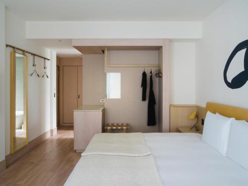 a bedroom with a large bed and a closet at Zentis Osaka in Osaka