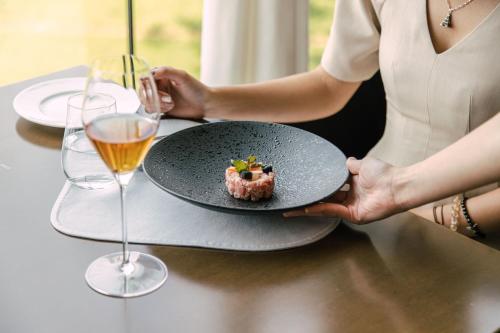 a woman holding a plate with a piece of food at JW Marriott Hotel Hanoi in Hanoi