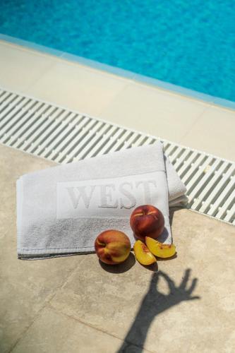 two apples and two bananas on a towel next to a pool at WEST HOUSE EXCLUSIVE HOTEL in Göcek