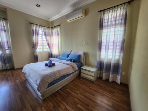 a bedroom with a large bed with blue pillows at Wakaf Bharu Garden Stay Semi-D By UJ in Kota Bharu