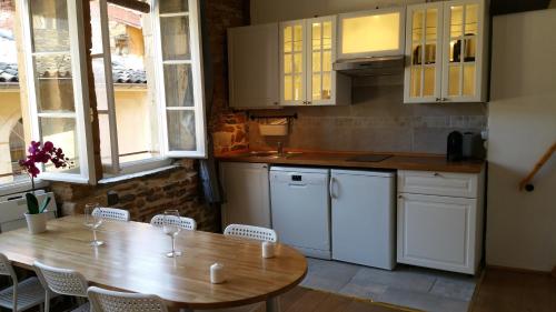a kitchen with a wooden table and white appliances at La Loge Du Vieux Lyon in Lyon