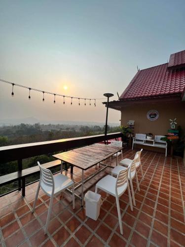 a patio with a table and chairs on a roof at บ้านภูไผ่ ไร่ภูไผ่เบิกตะวัน in Ban Nam Phang