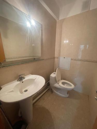 a bathroom with a sink and a toilet and a mirror at Your comfort is our responsibility in Ulaanbaatar