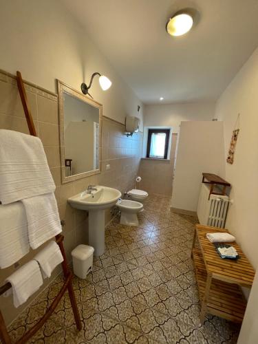 y baño con lavabo, aseo y espejo. en AGRITURISMO LA MOROLLA, en Marsciano