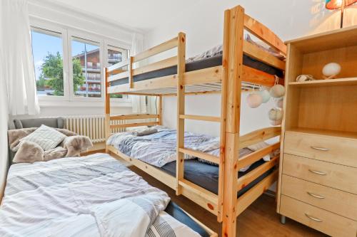 sypialnia z 2 łóżkami piętrowymi i łóżkiem w obiekcie Magnifique appartement à côté des remontées mécaniques w mieście Crans-Montana