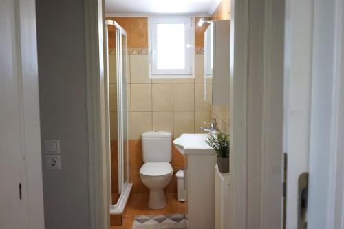 łazienka z toaletą, umywalką i oknem w obiekcie The Baker's Delight w mieście Kithira