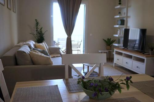 a living room with a couch and a table with a tv at The Baker's Delight in Kýthira