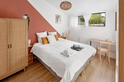 ein Schlafzimmer mit einem großen Bett und einem Schreibtisch in der Unterkunft L'Annexe - Maison cosy au calme avec jardin in Gorges