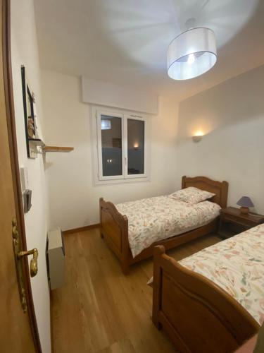 een slaapkamer met 2 bedden en een raam bij Le Saint Ju' in Friville-Escarbotin