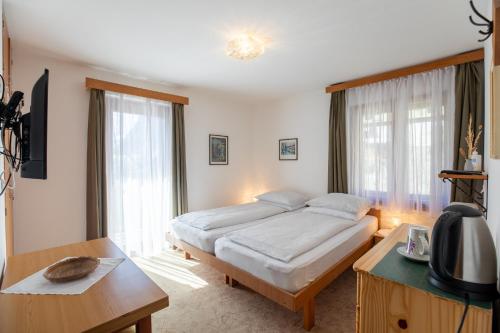 1 dormitorio con 1 cama, escritorio y TV en Sobe Odar Andrej en Bohinj