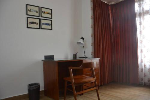 a desk with a lamp and a chair in a room at Earth - Luxurious 5 BHK AC Villa at Mysore in Mysore
