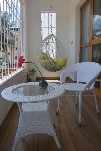 a room with a table and two chairs and a swing at Earth - Luxurious 5 BHK AC Villa at Mysore in Mysore