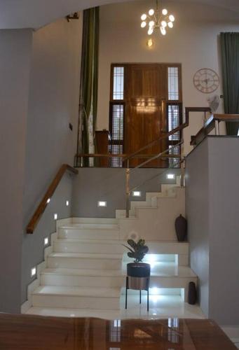 a staircase in a building with a potted plant at Earth - Luxurious 5 BHK AC Villa at Mysore in Mysore