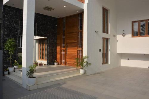 a front door of a house with potted plants at Earth - Luxurious 5 BHK AC Villa at Mysore in Mysore