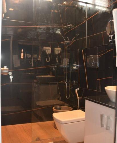 a bathroom with a toilet and a sink at Earth - Luxurious 5 BHK AC Villa at Mysore in Mysore