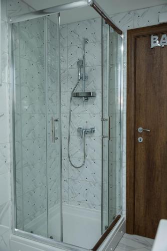 a shower with a glass enclosure in a bathroom at Marino Lux Prenoćište in Požarevac