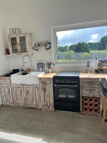 Il comprend une cuisine équipée d'une cuisinière et d'un évier. dans l'établissement La petite maison, à Plélan-le-Petit