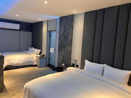 a hotel room with two beds with white sheets at MY Motel in Mingjian