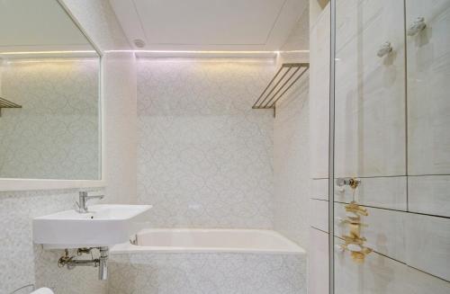 a white bathroom with a sink and a shower at Luxury home with sea views in St. Julianʼs