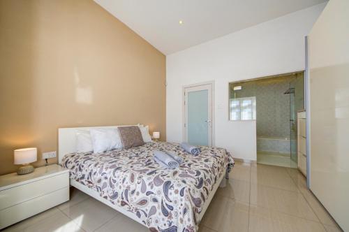 a bedroom with a bed and a walk in shower at Luxury home with sea views in St. Julianʼs