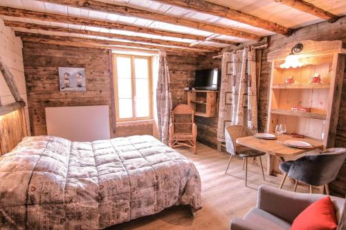 Schlafzimmer mit einem Bett und einem Tisch mit Stühlen in der Unterkunft LE SABOT DE VENUS in Termignon