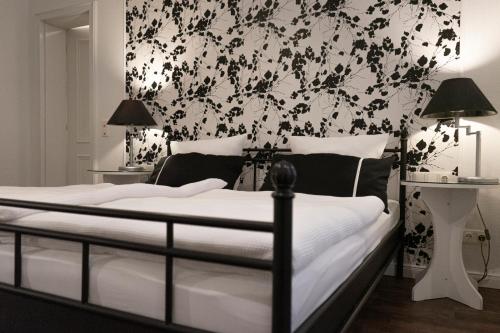 a bedroom with a bed with a black and white wallpaper at Rein Klassik Hotel in Bad Pyrmont