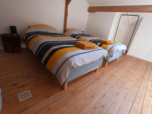 a pair of beds in a room with wooden floors at Maisonnette aux portes du Médoc in Blanquefort