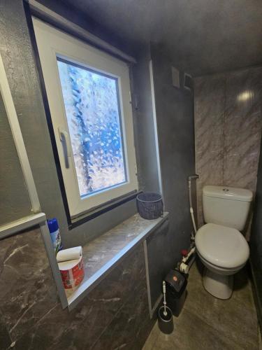 łazienka z toaletą i oknem w obiekcie Beqa house w mieście Tbilisi City
