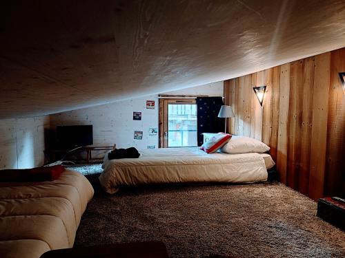 1 dormitorio con 2 camas y sofá en Résidence Chalet des Coeurs en Notre-Dame-de-Bellecombe