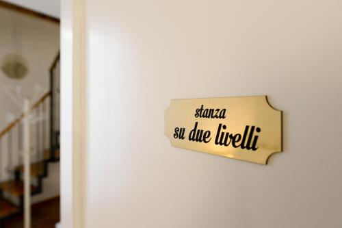 un signo que lee Santa se eleva Lucille colgando de una pared en AL DUOMO, Dimora Storica, en Matera