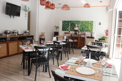 a restaurant with tables and chairs and a chef in the background at Mountain View Hotel in La Digue
