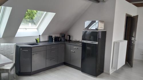 een keuken met een zwarte koelkast en een raam bij Wohnung Nr 4 in Bargischow