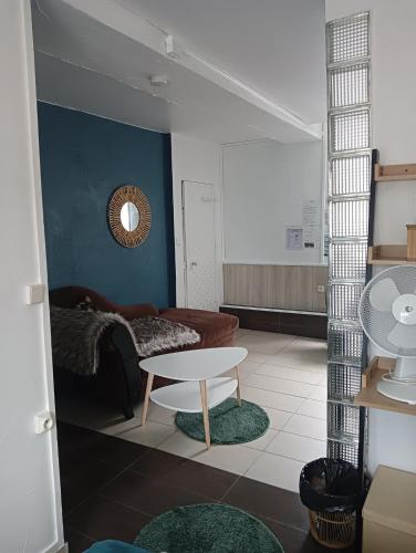 a living room with a couch and a table at Marie-Claire la grillade in Briare