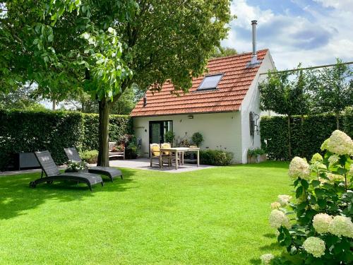 a yard with two benches and a table and a house at Heitse B&B en vakantiewoning in Heythuysen