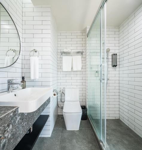 a bathroom with a toilet and a sink and a shower at Mii Hotel Srinakarin in Bangna