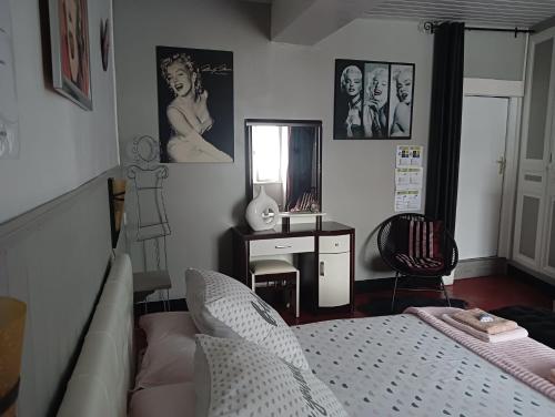 a bedroom with a bed and a desk and a mirror at Marie-Claire la grillade in Briare