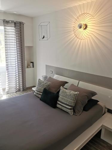 a bedroom with a large bed with pillows on it at Le Mas des Loges - Les Vans / Chambonas in Chambonas