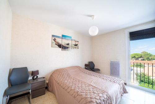 une chambre avec un lit et une fenêtre dans l'établissement Soleil et Mer - Appt climatisé proche plage, à Saint-Cyprien