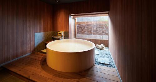 a large tub in a bathroom with a window at くろしお想 in Shirahama